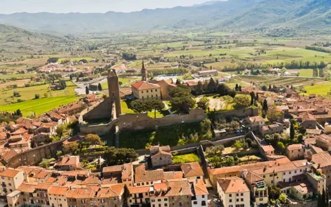 Vista aerea di un borgo medievale con torre, ideale per scoprire Arezzo e dintorni in 3 giorni.