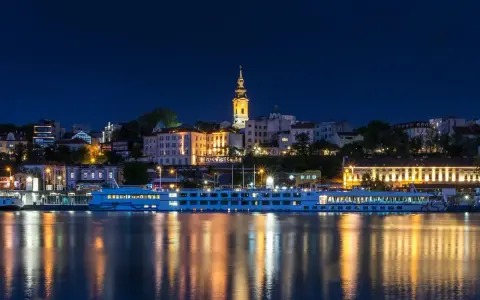 Nocny Belgrad z rzeką i statkiem wycieczkowym. Czy do Serbii potrzebny jest paszport? Sprawdź przed podróżą!
