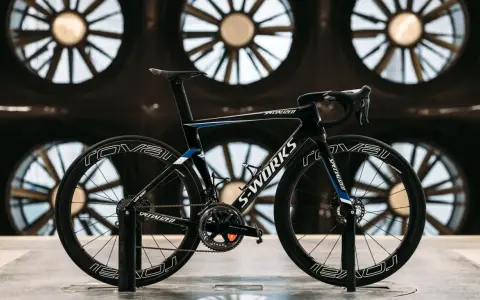 A black S-Works aero bike, designed for speed, is showcased in front of large industrial fans. This is what an aero bike looks like.