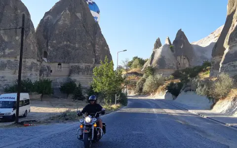 Niesamowita podróż motocyklem przez Kapadocję w Turcji. W tle widać latający balon i skalne formacje.