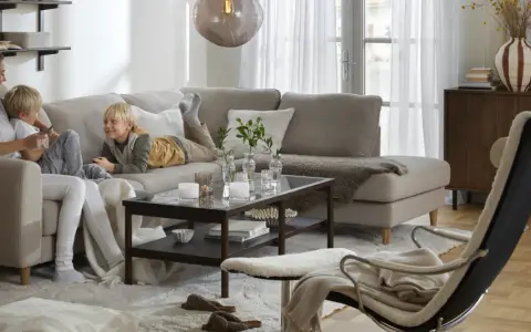 Familj myser i soffan. För att skydda tyget och göra det lättare att rengöra, kan man impregnera soffan.