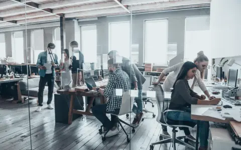 Persone lavorano in un ufficio moderno, un esempio di coworking cos'è: collaborazione e flessibilità in un ambiente dinamico.