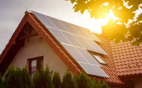 Panele słoneczne na dachu domu łapią promienie słońca, zapewniając czystą energię.