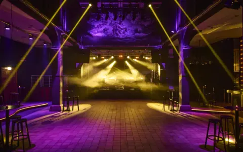 Scenljus och rök fyller en tom lokal i slakthusområdet Stockholm, redo för en kväll med musik och fest.
