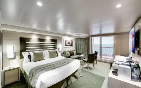 Lussuosa cabina nave con letto king-size, divano, balcone vista mare e TV.