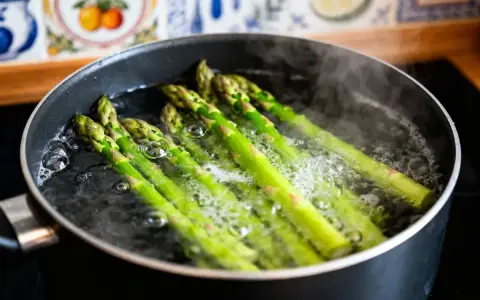 Asperges vertes bouillonnant dans une casserole, prêtes pour une recette simple et savoureuse.