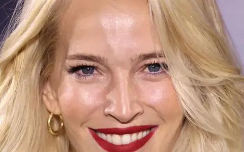 Una mujer sonríe, mostrando cómo cuidar la piel de la cara a los 50 con una piel radiante y maquillaje impecable.