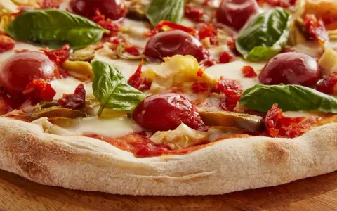 Pyszna pizza włoska z pomidorkami, mozzarellą i bazylią. Idealna na letni wieczór.