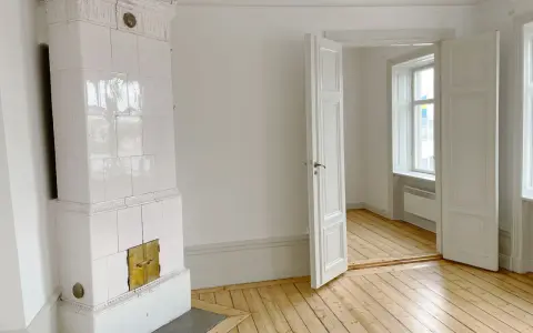 Vitt, vackert kakelugn med mässingsluckor. Tänk att elda i kakelugn en kall vinterdag.