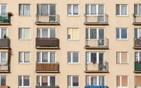 Façade d'immeuble avec de nombreux balcons et fenêtres, offrant un aperçu de la vie quotidienne et du **logement décent**.