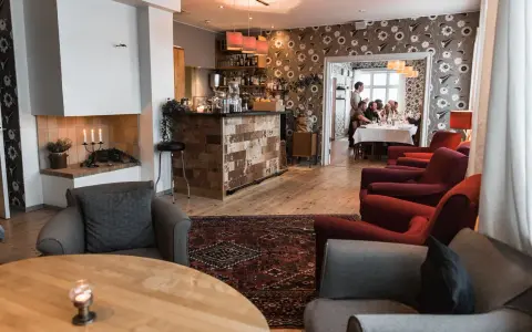 Mysig interiör på meteorologen ski lodge med öppen spis, bar och gäster som äter middag.