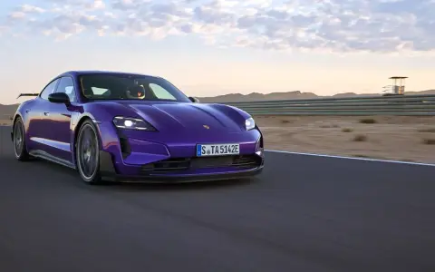 Fioletowe Porsche Taycan na torze wyścigowym podczas zachodu słońca.
