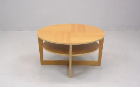 Rundt, ljust träbord med två hyllplan, en klassisk IKEA VEJMON EK. Perfekt för vardagsrummet.