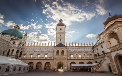 Piękny dziedziniec zamku Krasiczyn zachęca do zwiedzania. Architektura zachwyca pod błękitnym niebem.