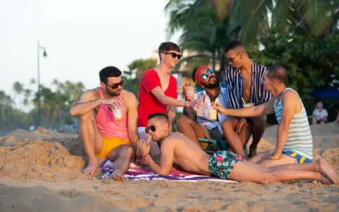 Friends enjoy drinks on the beach, a perfect day at a San Juan gay resort.