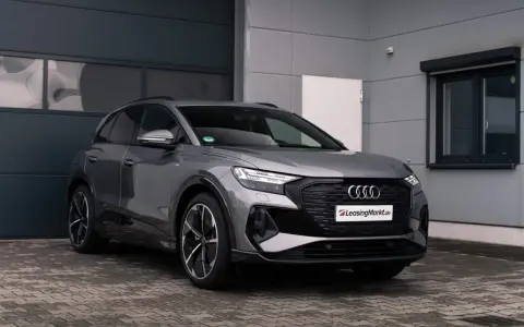 Grauer Audi q4 e tron steht vor einer Garage.