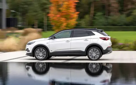 Biały Opel Grandland w ruchu, z refleksami na wodzie. Sprawdź aktualną opel grandland cena i wybierz swój wymarzony SUV.