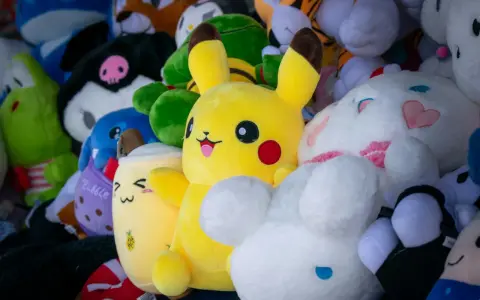 Pluszaki, jak Pikachu i króliczek, czekają na pranie. Kolorowe, miękkie zabawki w różnych kształtach.