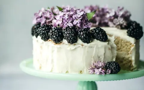 Biały tort z jeżynami i bzem, idealny przykład najmodniejszych smaków tortów.