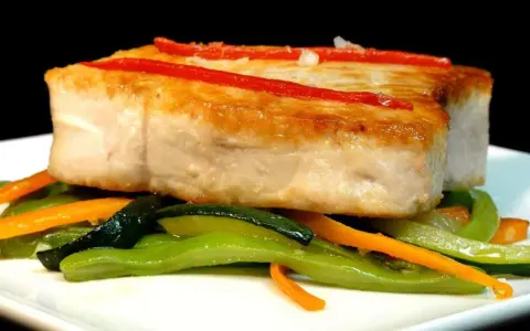 Bonito jugoso con pimientos rojos y verduras salteadas. Una delicia para aprender como cocinar el bonito para que quede jugoso.