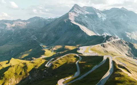 Strada tortuosa in montagna, ideale per un'avventura in moto in Austria. Panorami mozzafiato e curve infinite.