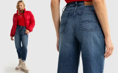 Kobieta w czerwonej kurtce i czerwonym T-shircie prezentuje modne **szerokie jeansy stylizacje**. Luźny krój i jasny denim tworzą swobodny look.