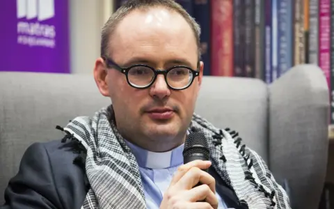Ksiądz Kaczkowski, w okularach i z szalem, dzieli się cytatami o życiu.
