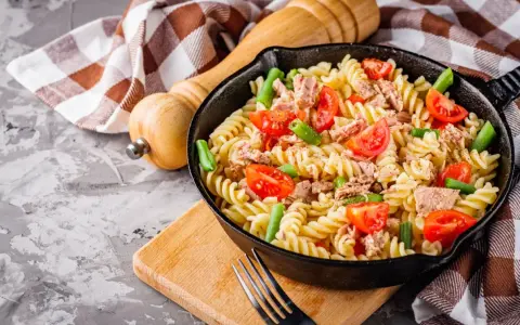 Makaron z tuńczykiem, pomidorkami i fasolką szparagową w patelni.
