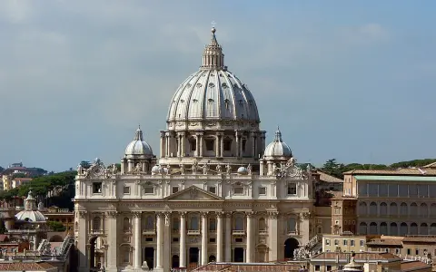 La majestueuse hauteur de la basilique Saint-Pierre domine le ciel romain, ses dômes imposants se détachant sur un ciel bleu clair.