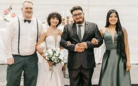 Sposi con due testimoni, un uomo e una donna, sorridono felici. Il rito civile quanti testimoni? Due sono sufficienti per suggellare l'amore.