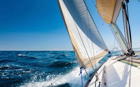 Segelboot gleitet über das Meer, das Takelage schiff ist gut sichtbar, blauer Himmel und Wellen.