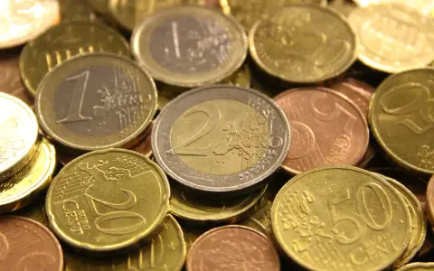 Gros plan sur une pile de pièces en euros de 2002. On distingue des pièces de 1 euro, 2 euros, 20 centimes et 50 centimes.