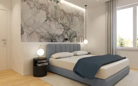 Idee per cosa mettere su un comò in camera da letto: un tavolino nero con lampada, libri e un vaso con fiori secchi.