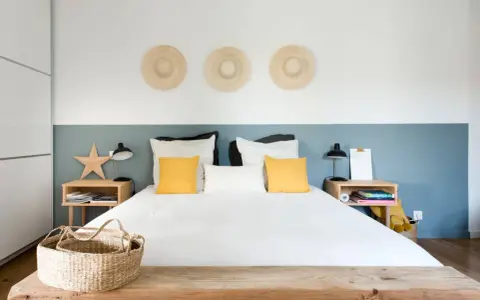 Décoration murale avec trois chapeaux de paille pour comment donner de la hauteur à un plafond bas. Chambre moderne et lumineuse.