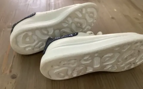 Białe sneakersy Alexander McQueen z granatowymi brokatowymi wstawkami. Zwróć uwagę na charakterystyczną podeszwę, by jak rozpoznać oryginalne buty Alexander McQueen.