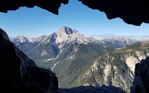 Vista mozzafiato dal **Monte Piana**, con valli profonde, foreste rigogliose e cime maestose sotto un cielo azzurro.