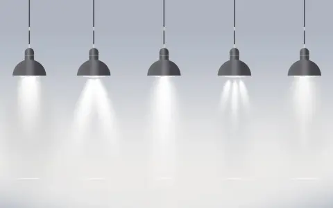 Pięć wiszących lamp tworzy oświetlenie miejscowe, rzucając snopy światła na pustą przestrzeń.