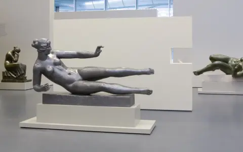 Exposition d'œuvres d'art de Aristide Maillol : sculptures de femmes nues en bronze et en métal, dans un musée.