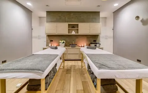 Dwie leżanki do masażu, świece i kwiaty tworzą atmosferę relaksu. Idealne miejsce na 2-dniowy pobyt w spa dla dwojga.