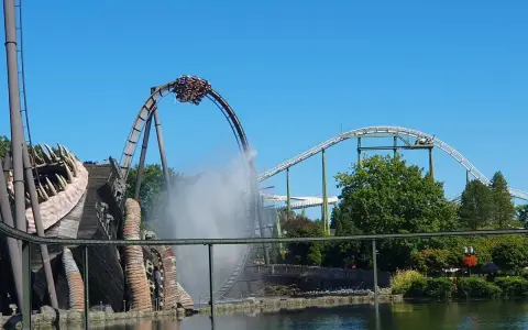 Achterbahn im Heide Park mit Wassereffekt und einem großen Holzmonster.