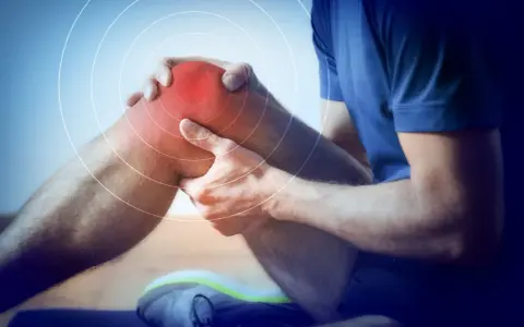 Ból kolana sportowca, który wymaga rehabilitacji sportowej. Czerwony obszar i kręgi wskazują na uraz.