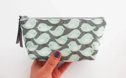 Trousse à maquillage avec motif d'oiseaux, parfaite pour une liste de maquillage pour débutant.