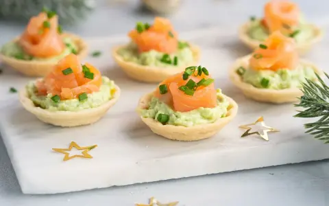 Canapés de salmón y aguacate, un picoteo fácil y rápido para cualquier celebración. Decorados con cebollino y estrellas doradas.