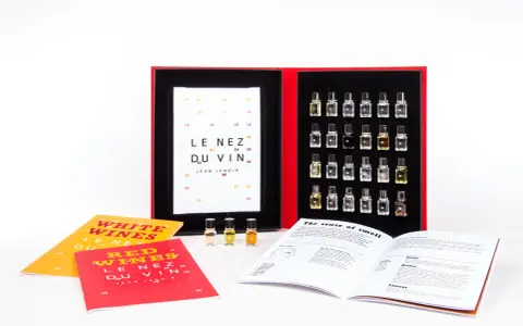 Kit de degustación "Le Nez du Vin" con pequeños frascos de aromas, libros y una tabla de cata.
