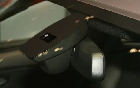 Nahaufnahme eines Regensensors im Auto, der die Windschutzscheibe überwacht, um bei Regen die Scheibenwischer zu aktivieren.