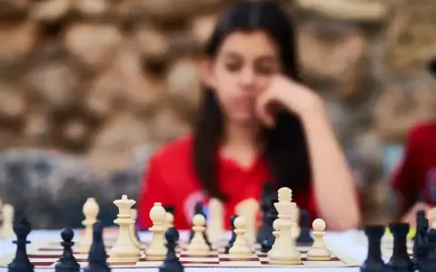 Niña pensativa frente a un tablero de ajedrez, inmersa en los juegos de decisiones.