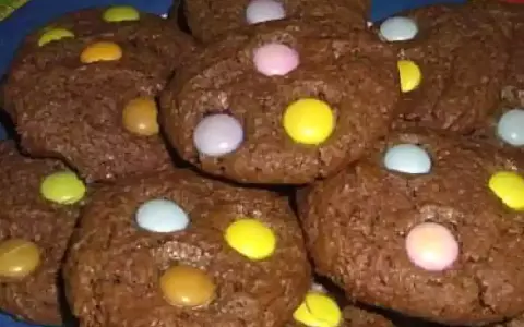Gros plan sur des cookies chocolat garnis de Smarties colorés. Un délice gourmand pour petits et grands.