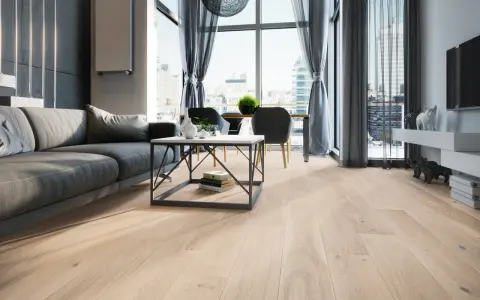Nowoczesny salon szaro beżowy z szarą kanapą, stolikiem kawowym i widokiem na miasto.