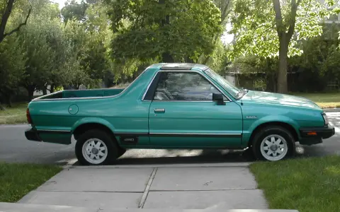 Zielony Subaru Brat z lat 80. stoi na podjeździe, gotowy na przygodę.