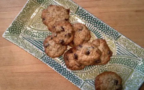 Leckere sauerteig cookies mit Schokoladenstückchen auf einer grünen, gemusterten Platte.